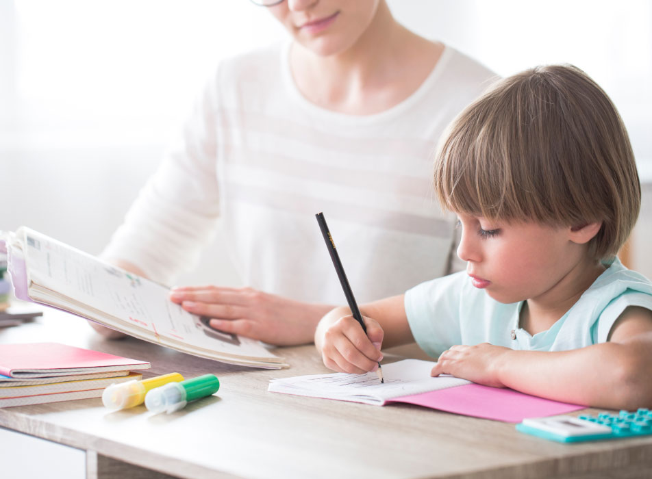 child-being-helped-with-homework Child writing